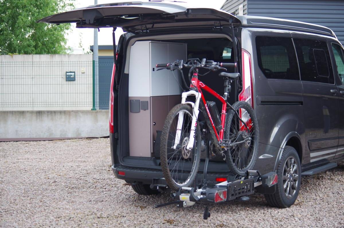 Bras pivotant pour porte-vélos sur boule d’attelage Swing-Flex Bras pivotant pour porte-vélos sur boule d’attelage Swing-Flex installé sur un van Ford Custom