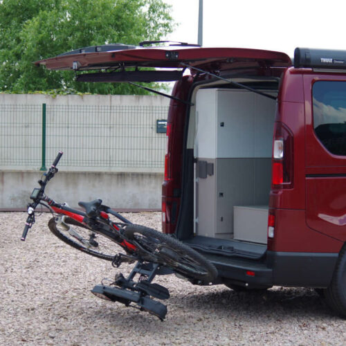 Porte-vélo sur boule d'attelage pour Fourgons Renault Trafic 3 Porte-vélos replié avec un VAE chargé et hayon du van ouvert